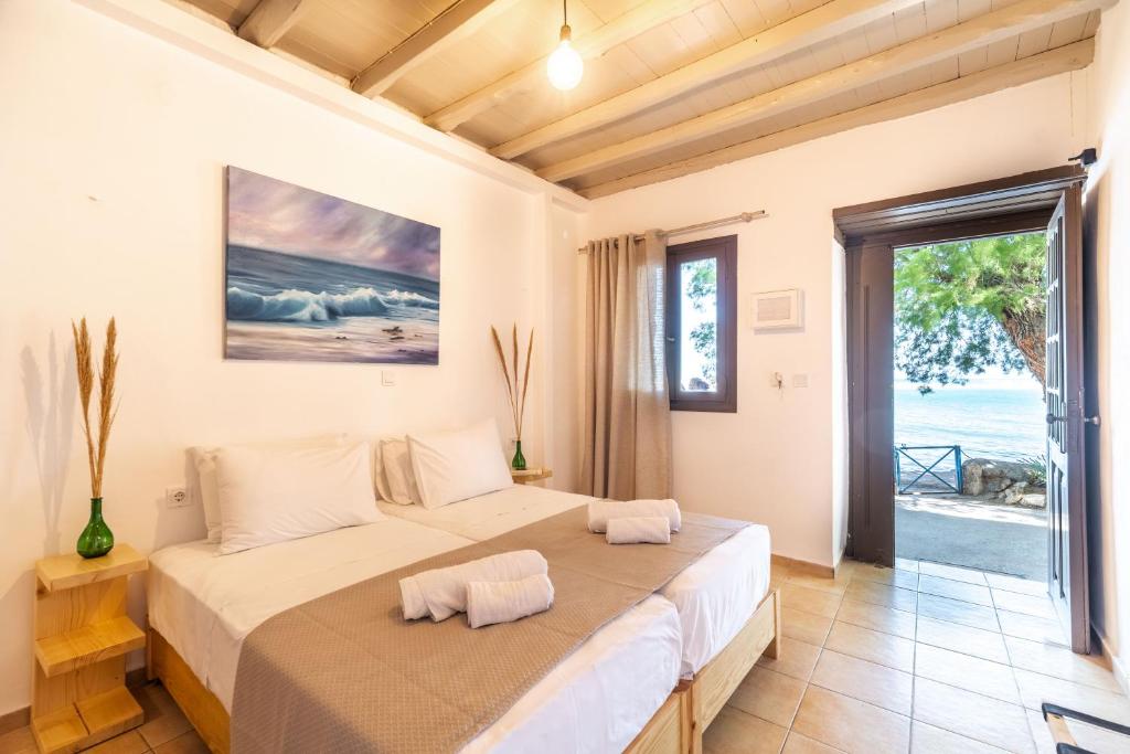 sypialnia z dużym łóżkiem i dużym oknem w obiekcie Mylos Seaside Experience w mieście Frangokastello