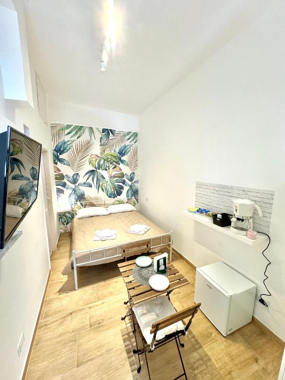 a bedroom with a bed and a desk and chairs at Bari annette room in Bari