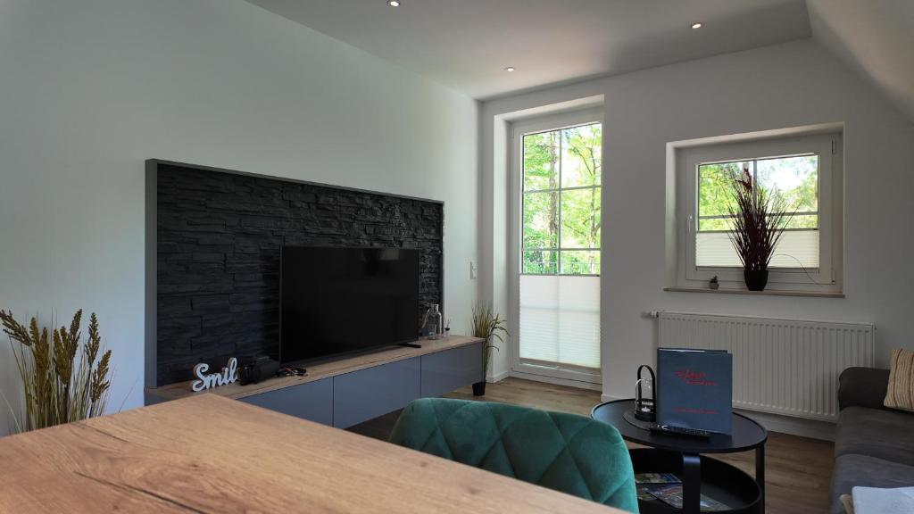 uma sala de estar com uma televisão e uma lareira de tijolos em Klosterhof Aue W 7 em Bad Zwischenahn
