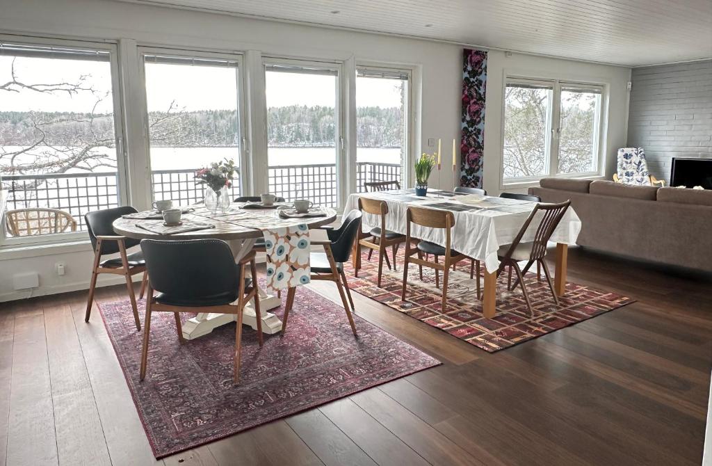 uma sala de jantar com uma mesa e cadeiras e um sofá em The Luxurious Lakeview Villa near Stockholm em Estocolmo