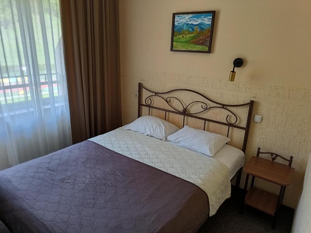 1 dormitorio con 1 cama grande con sábanas blancas en Girska Tysa Health Resort en Kvasy