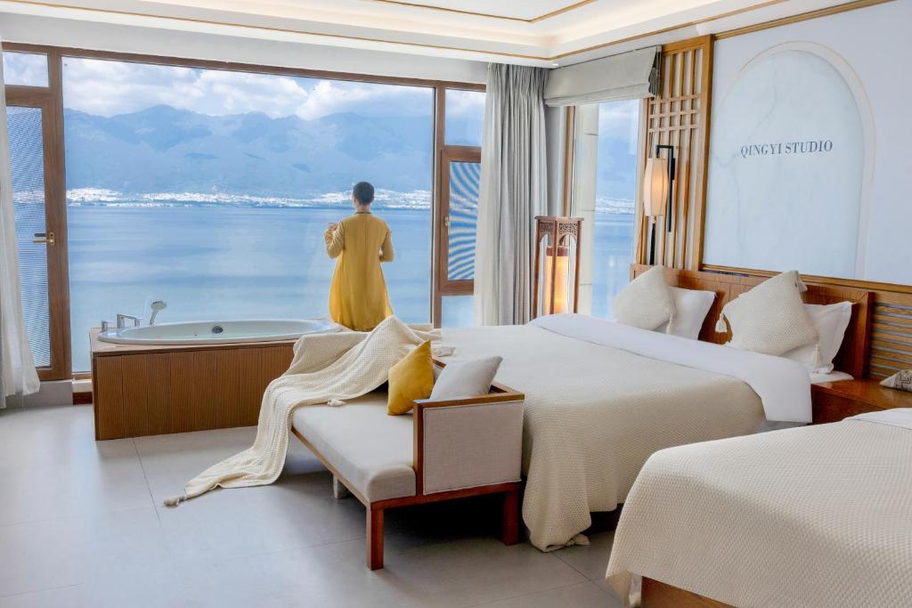 大理市にあるDali Dare Sea View Gueshouseのベッド2台とバスタブ付きのホテルルームです。
