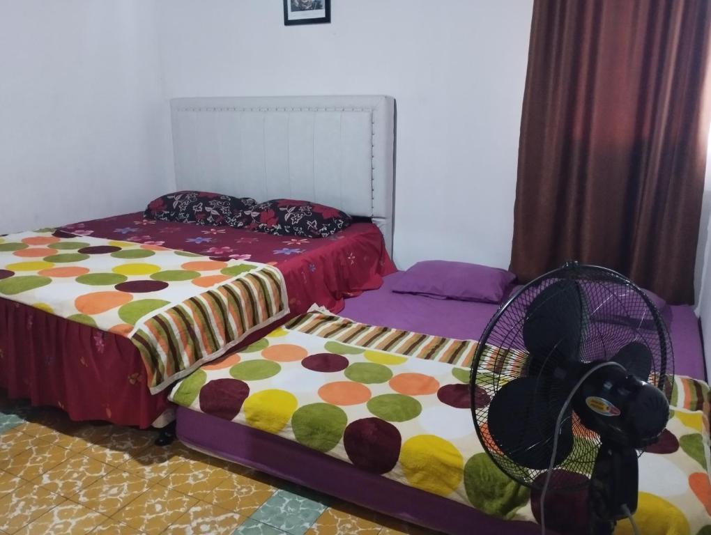 Postel nebo postele na pokoji v ubytování Hasbi Homestay Syariah
