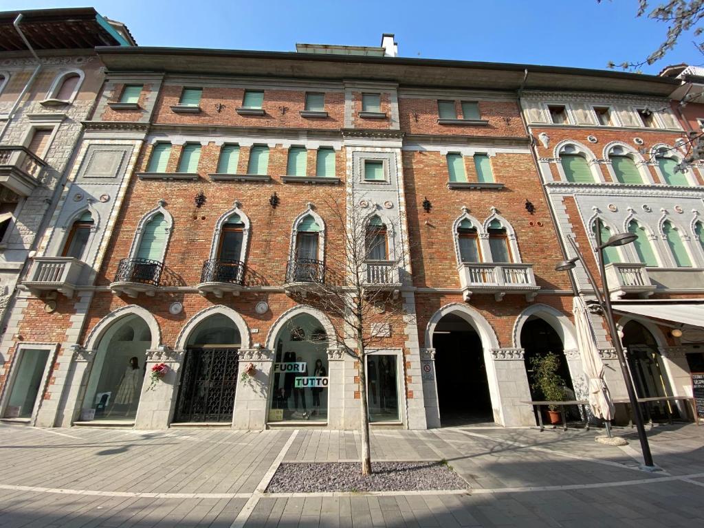 a red brick building with a tree in front of it at Condominio Fari in Grado