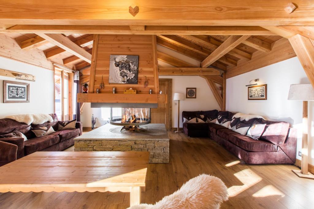 a living room with couches and a fireplace at Chalet familial La Griotte avec piscine in Praz-sur-Arly