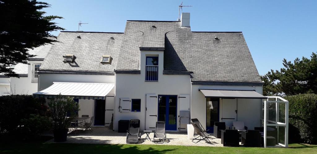 une maison blanche avec un toit et une terrasse dans l'établissement Babounia, à Batz-sur-Mer
