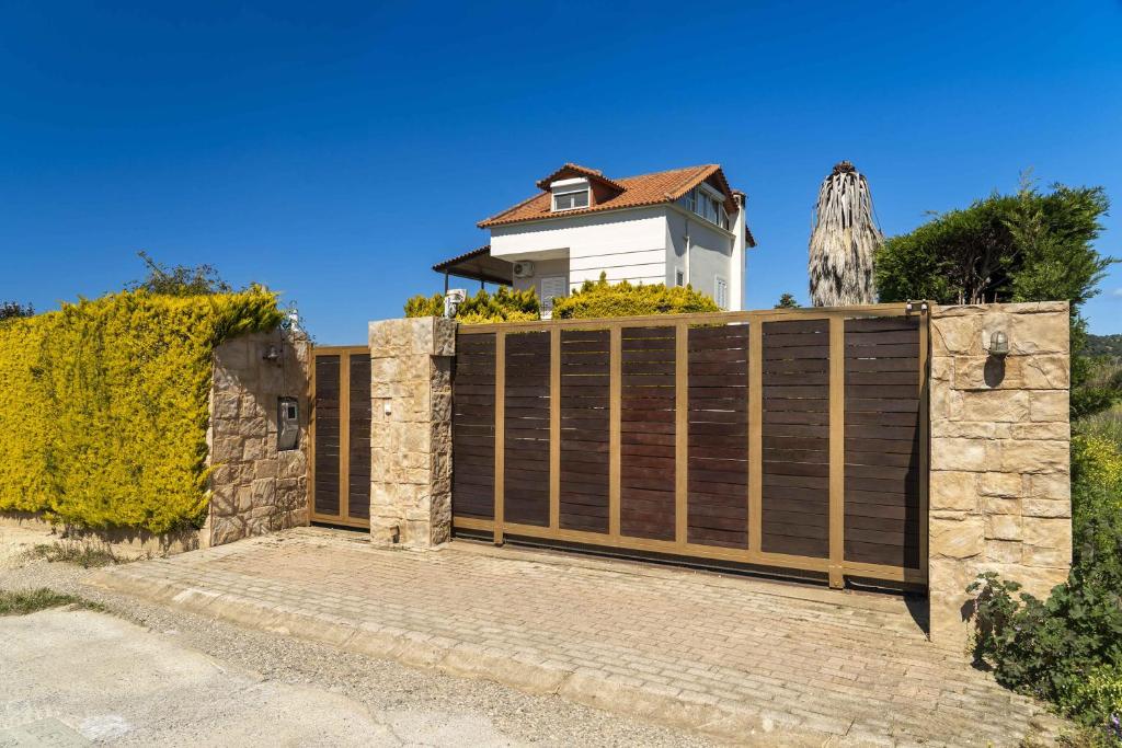 a wooden fence with a gate in front of a house at Meliti Villa in Píla