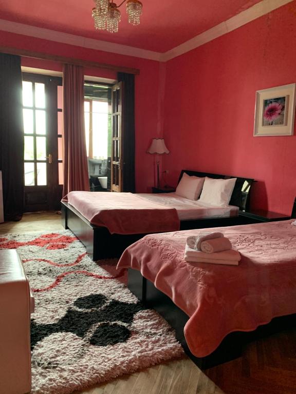 two beds in a bedroom with red walls at Hotel Villa DavidL in Sagarejo