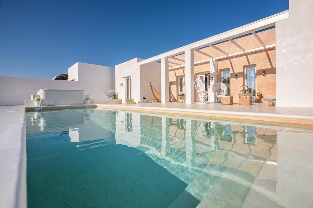 a swimming pool in front of a house at The Cycladic Pavilion Naxos in Galanado