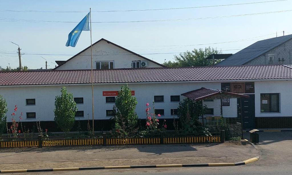 um edifício com uma bandeira em cima em Elite Capsule Hotel em Balkhash
