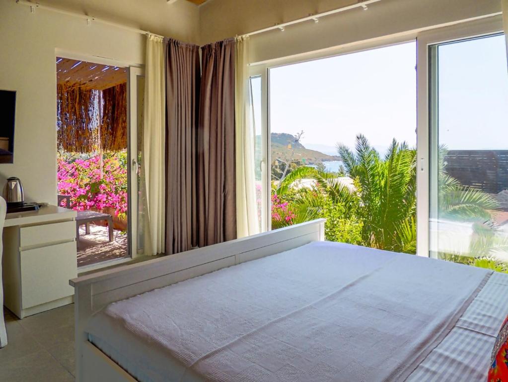 a bedroom with a bed and a large window at Oza Boutique hotel in Gümüşlük