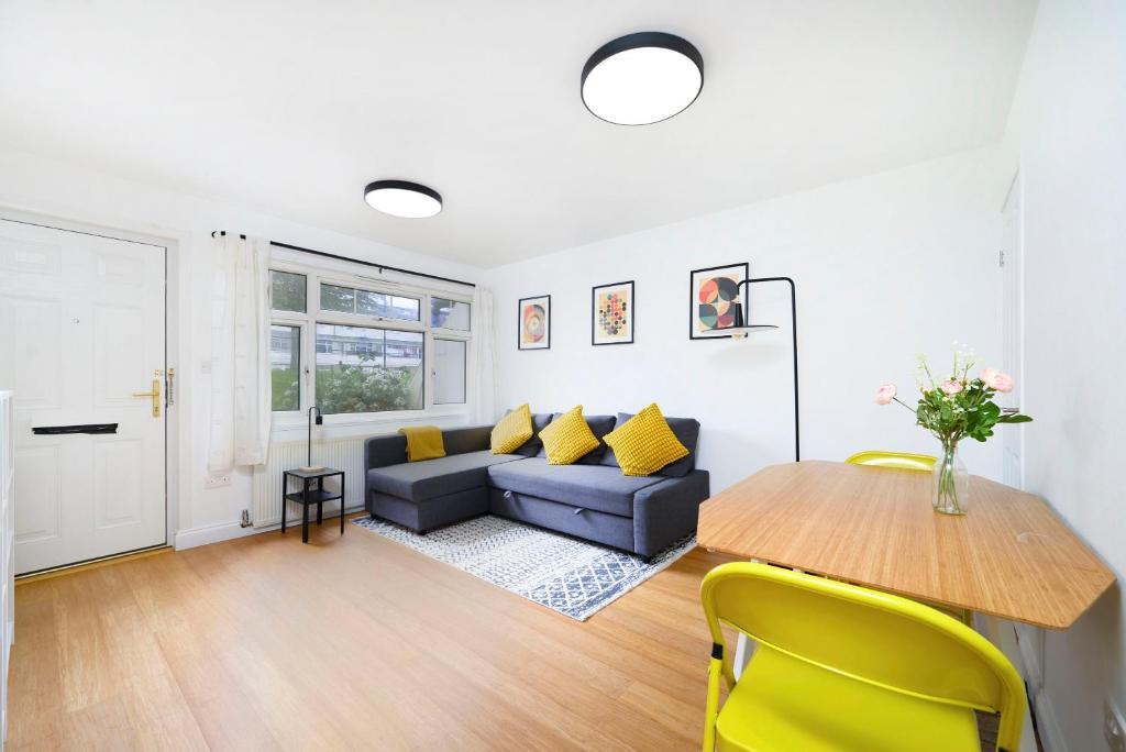 een woonkamer met een bank en een tafel bij Beautiful 1BR Flat in The Heart of Croydon in Croydon