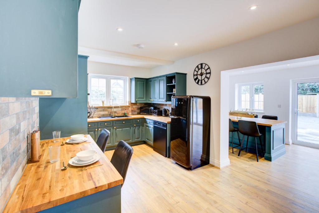 uma cozinha com armários verdes e uma mesa de madeira em Spacious Upstairs Bedroom Ensuite with Free Parking - Room 4 em Brentwood
