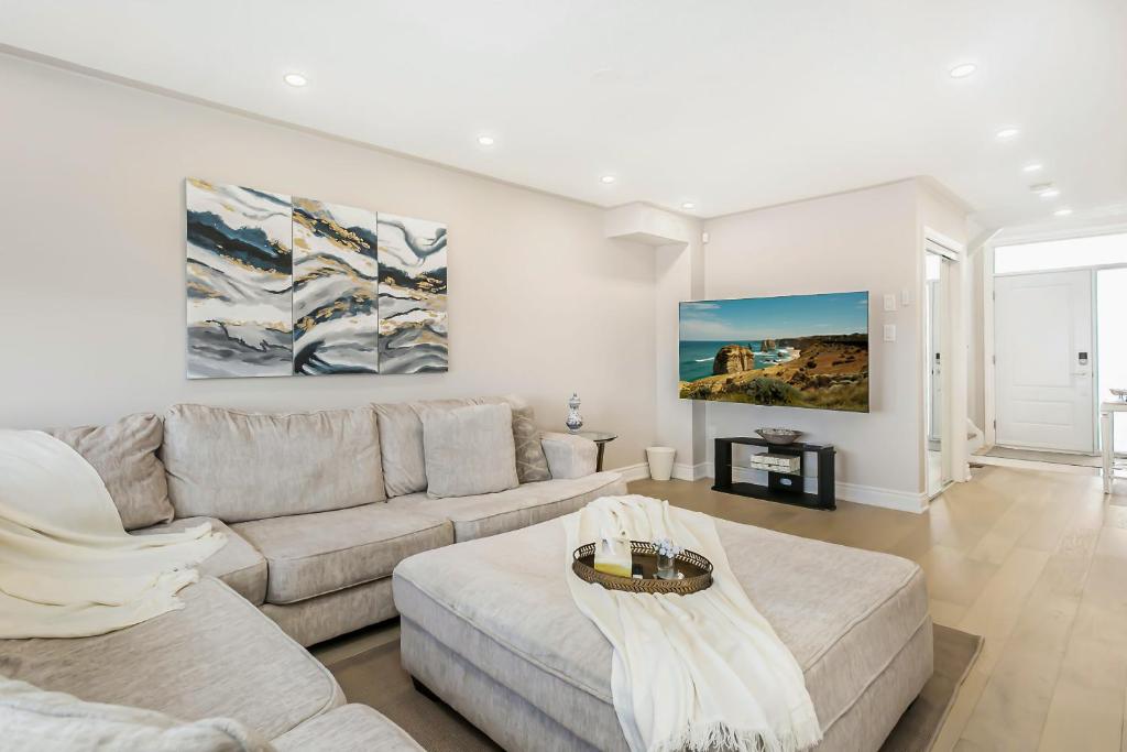 a living room with a couch and a table at Bright 4 BR Family Home , Sleeps 8, Near Wonderland and Vaughan Mills in Vaughan