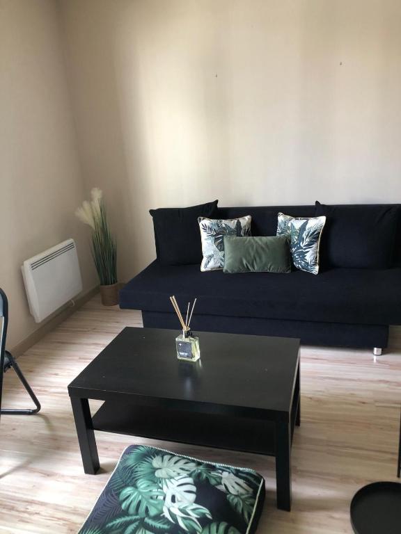 un salon avec un canapé bleu et une table basse dans l'établissement Les Jardins d'Hermès, à Troyes