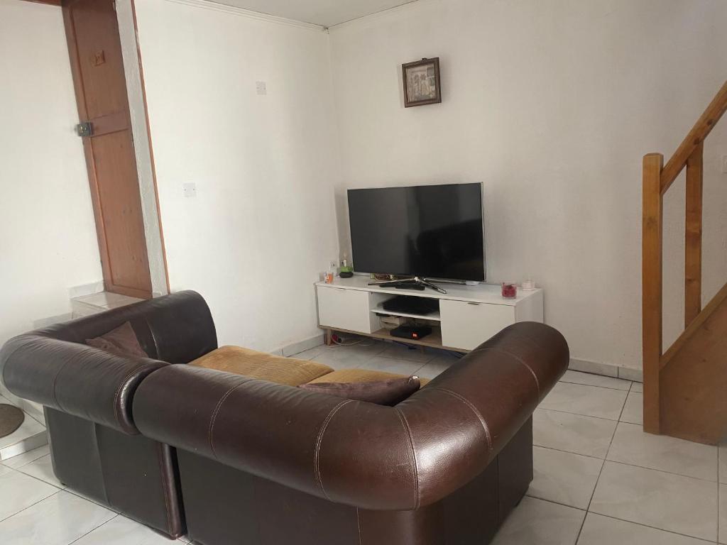 un salon avec un canapé en cuir et une télévision dans l'établissement Maison Gallus, à Gallargues-le-Montueux