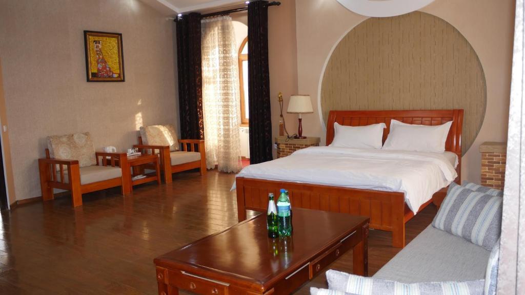 een slaapkamer met een bed en een tafel in een kamer bij HOTEL DIOR in Doesjanbe