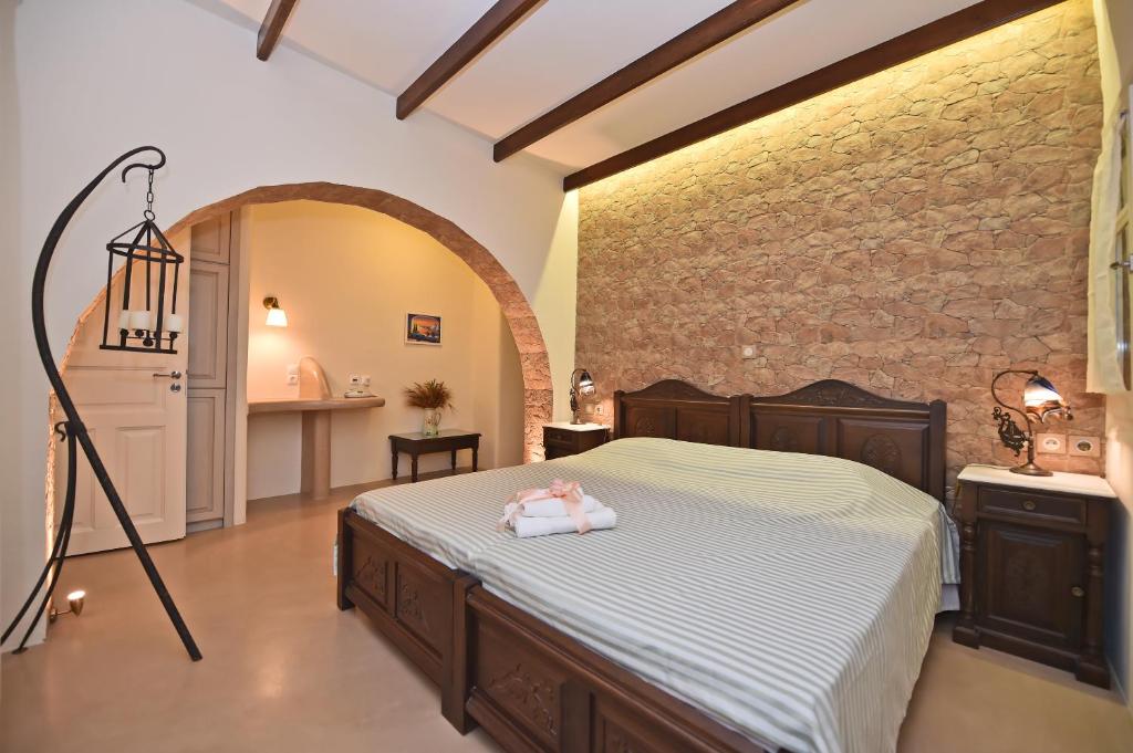 a bedroom with a bed with a doll on it at Tinos Aqua Palazzo in Tinos