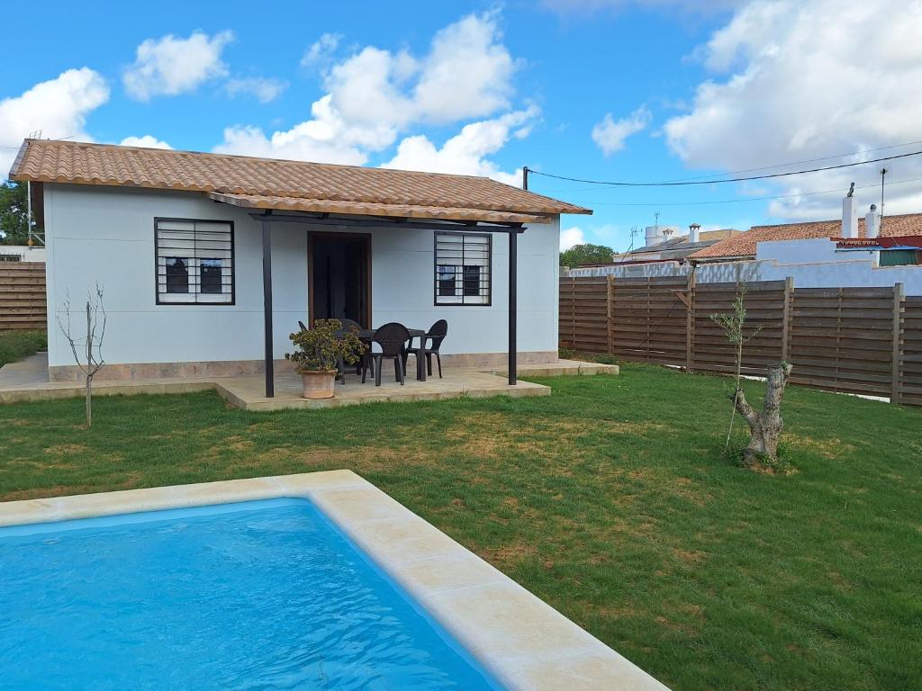 een klein huis met een zwembad in een tuin bij Casa vacacional en Chiclana de la Frontera in Chiclana de la Frontera