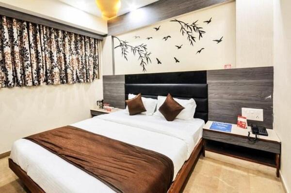 a bedroom with a bed with birds on the wall at Hotel Krishna Naroda in Ahmedabad