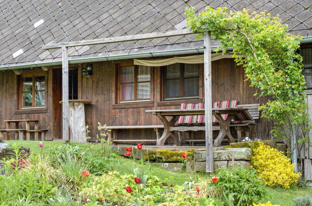 une maison en bois avec une table et des chaises dans la cour dans l'établissement Ferienwohnung Metzgerbauernhof, à Wolfach