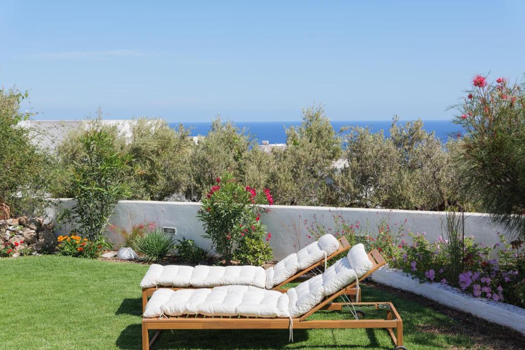 kanapę siedzącą na trawie w ogrodzie w obiekcie Sea you soon- Amazing Sea view w mieście Achlia