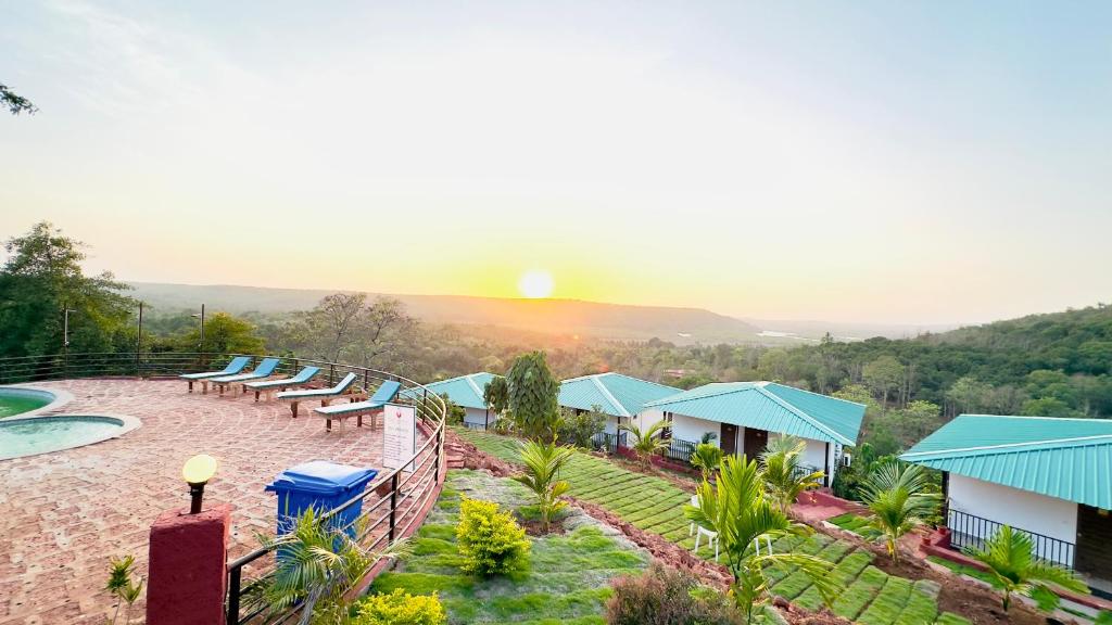 een uitzicht op een resort met een zonsondergang op de achtergrond bij Cashew leaf resort in Arambol