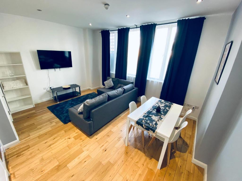 a living room with a couch and a table at 2 Bedroom Flat - 2 Bath - 15 min Camden Town in London