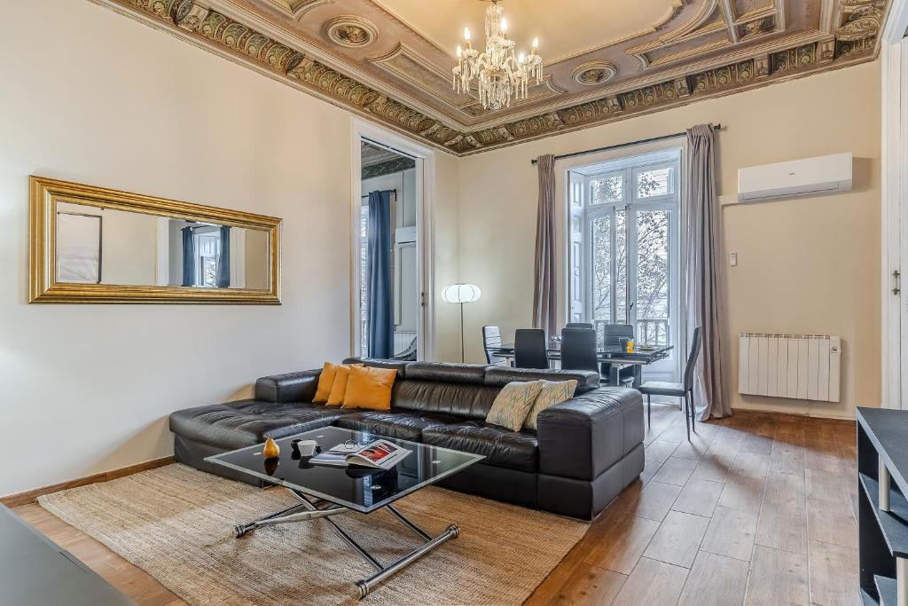 AB Bruc City Center في برشلونة: غرفة معيشة مع أريكة جلدية سوداء وطاولة