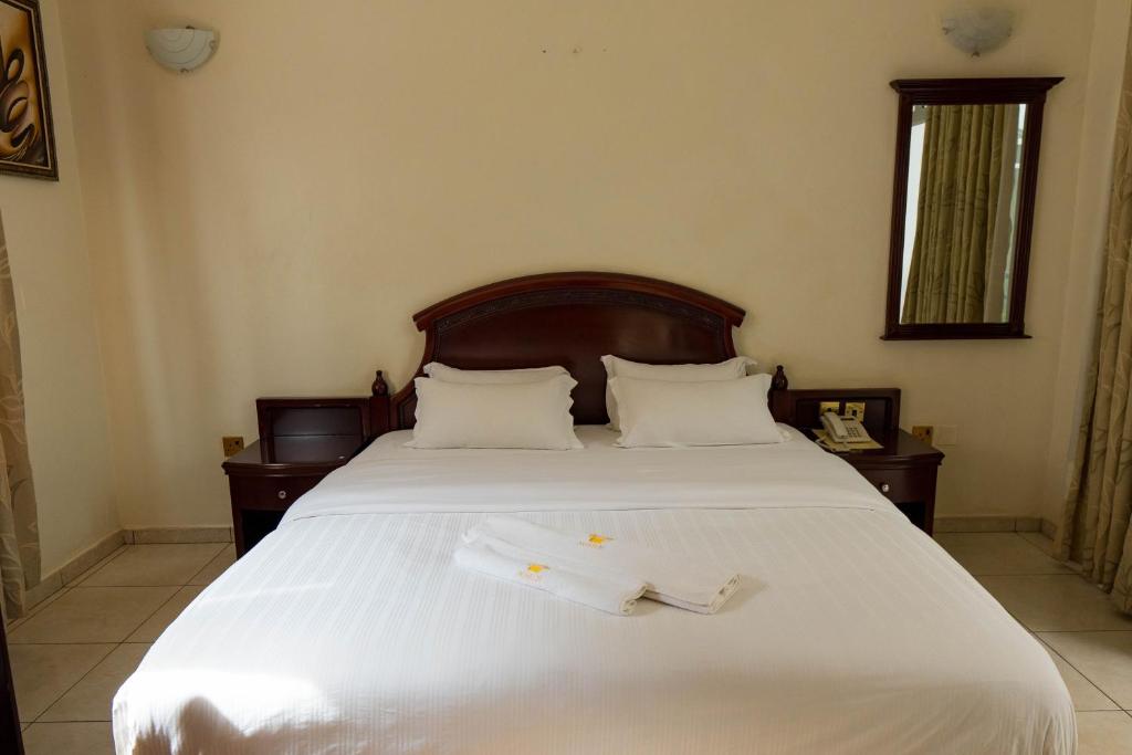 a bedroom with a bed with two white towels on it at Nobilis Hotel and Apartments in Kigali
