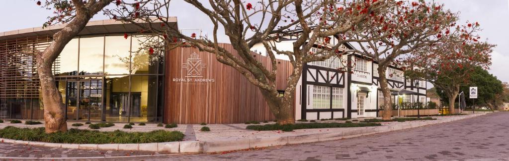 a building on a street with trees in front of it at Royal St. Andrews Hotel, Spa and Conference Centre in Port Alfred