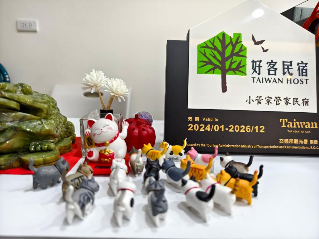 un grupo de figuritas de juguete sentadas junto a una caja en Little Butler B&B, en Huxi