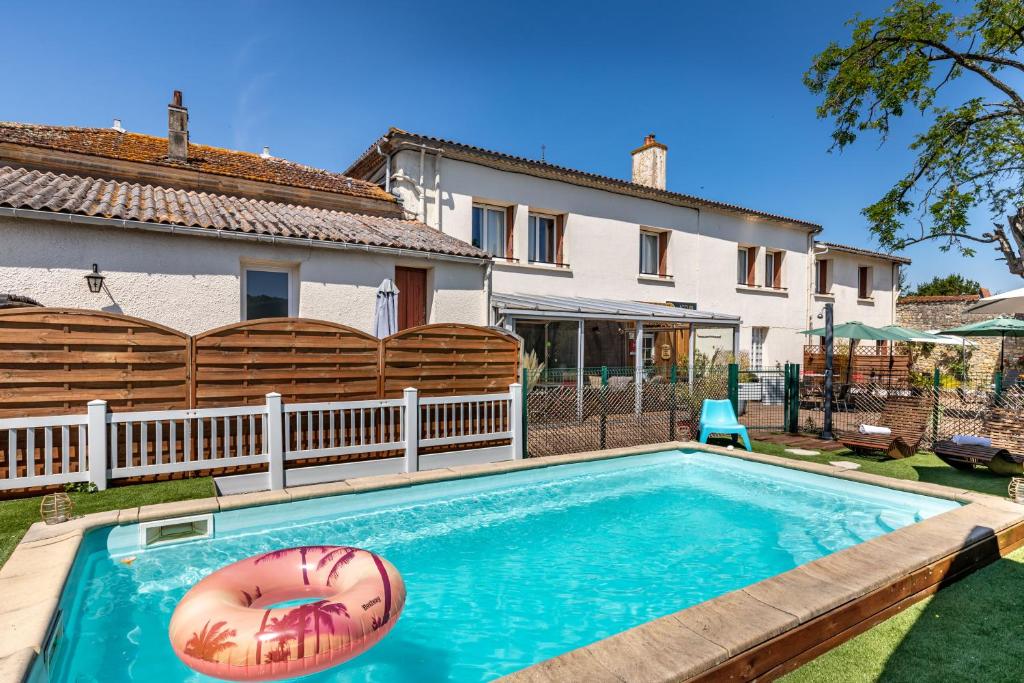 a swimming pool in the backyard of a house at Hotel Les Vieux Acacias in Queyrac