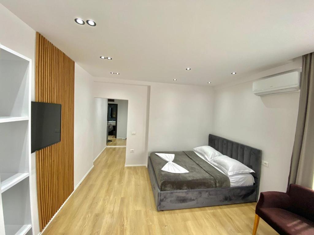 um quarto com uma cama e uma televisão em Mara Central Apartment 4 em Tirana