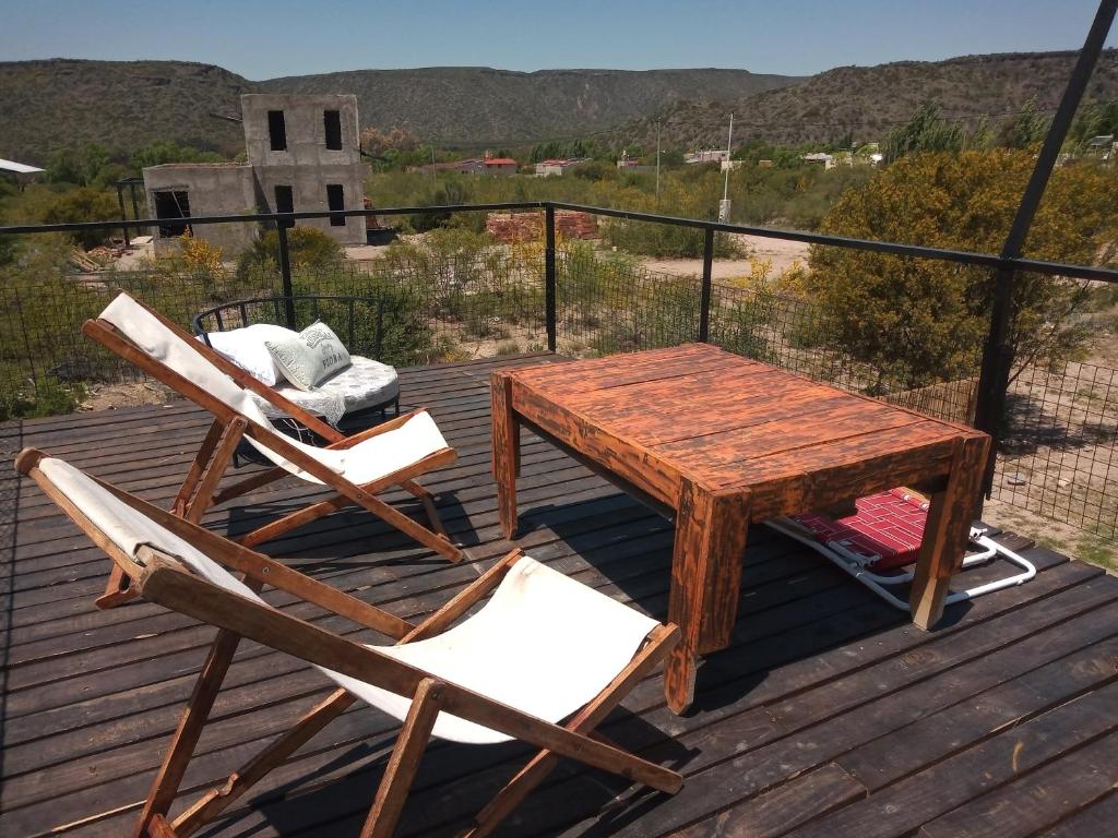 a wooden table and two chairs on a deck at Espectacular Cabaña En Valle Grande Terraza Panorámica 360 in Valle Grande
