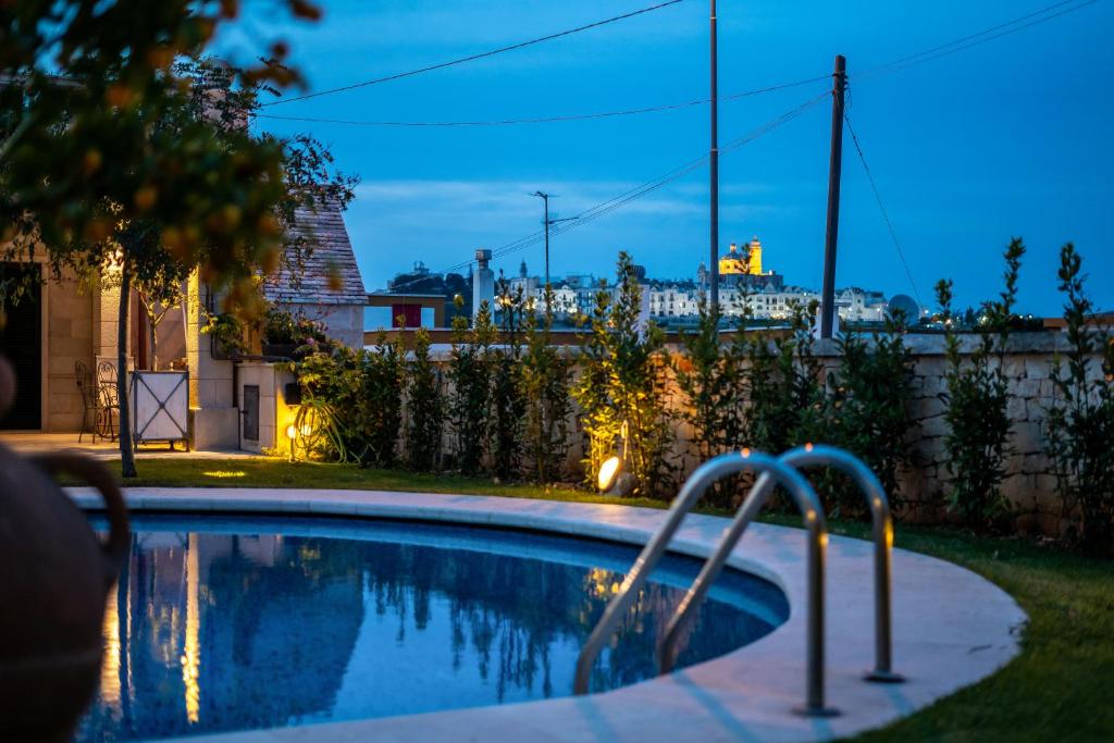 a swimming pool in a backyard at night at Villa Caramia in Locorotondo