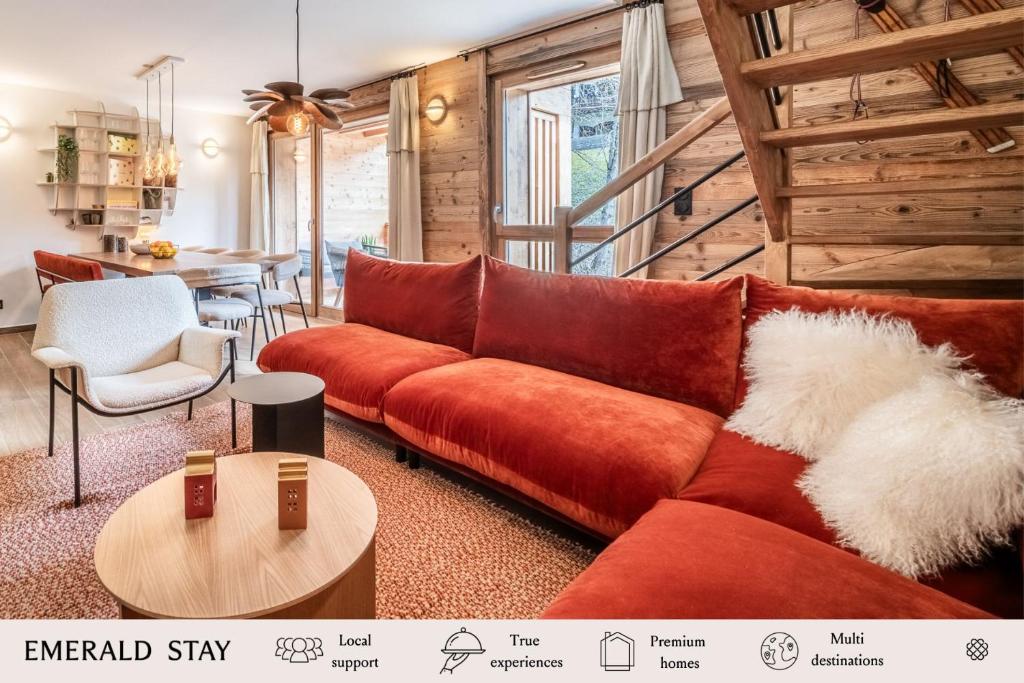 un salon avec un canapé rouge et une table dans l'établissement Apartment Colibri Les Gets - by EMERALD STAY, aux Gets