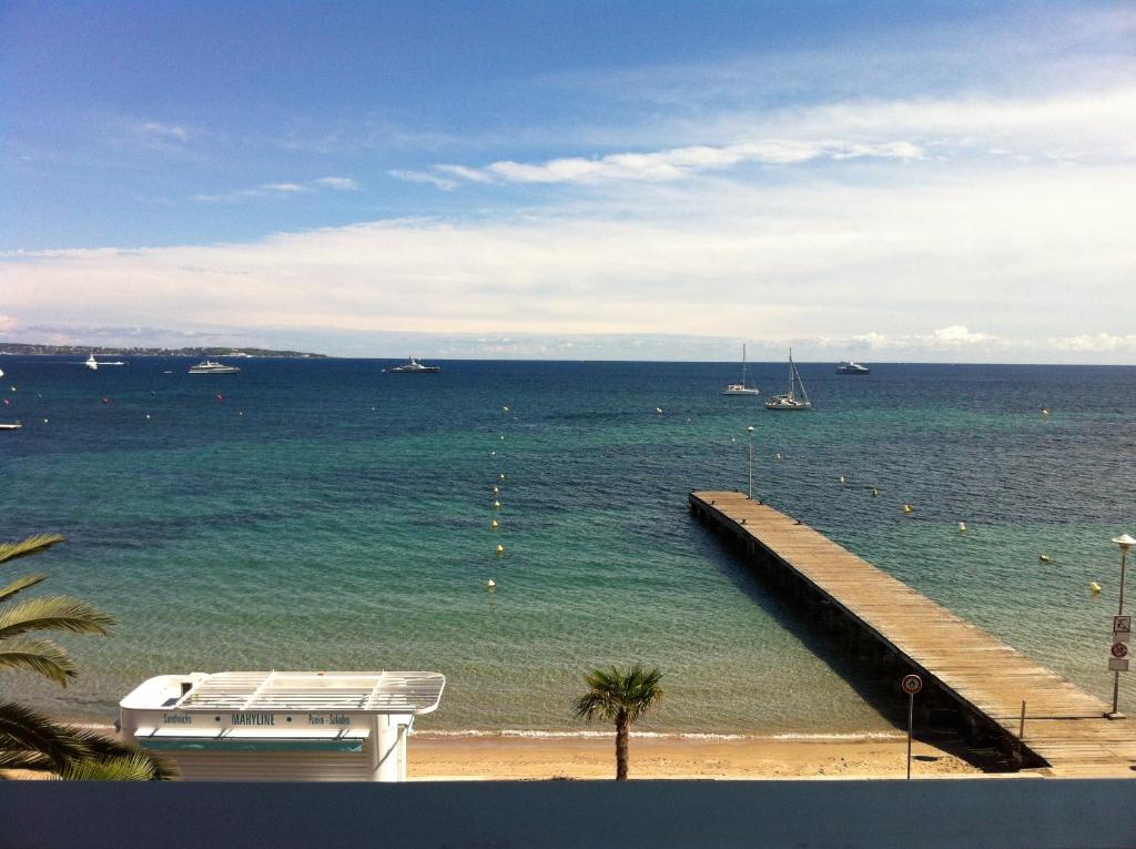 une vue sur l'océan avec une jetée et un bateau dans l'établissement Studio Cannes bord de mer, à Cannes