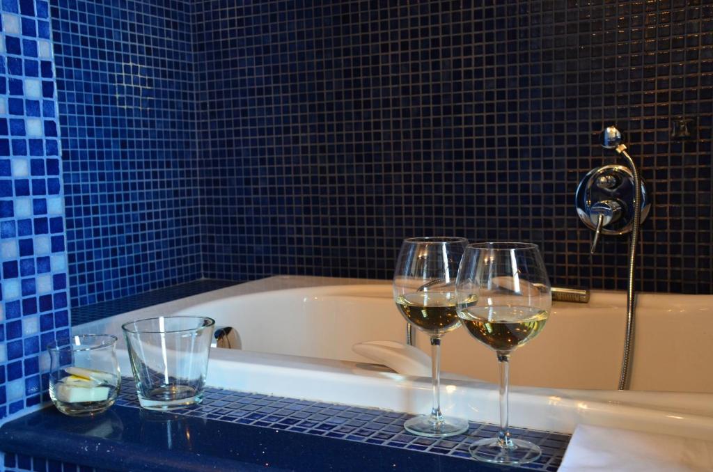 trzy kieliszki wina na blacie obok wanny w obiekcie FeWo CIELO mit Terrassen und und einen atemberaubenden Blick w mieście Terricciola