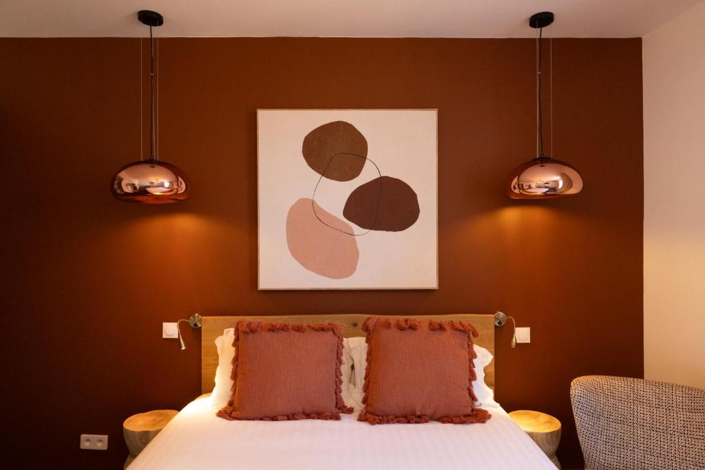 ビアリッツにあるHôtel Barneaのベッドルーム1室(枕2つ、絵画付)