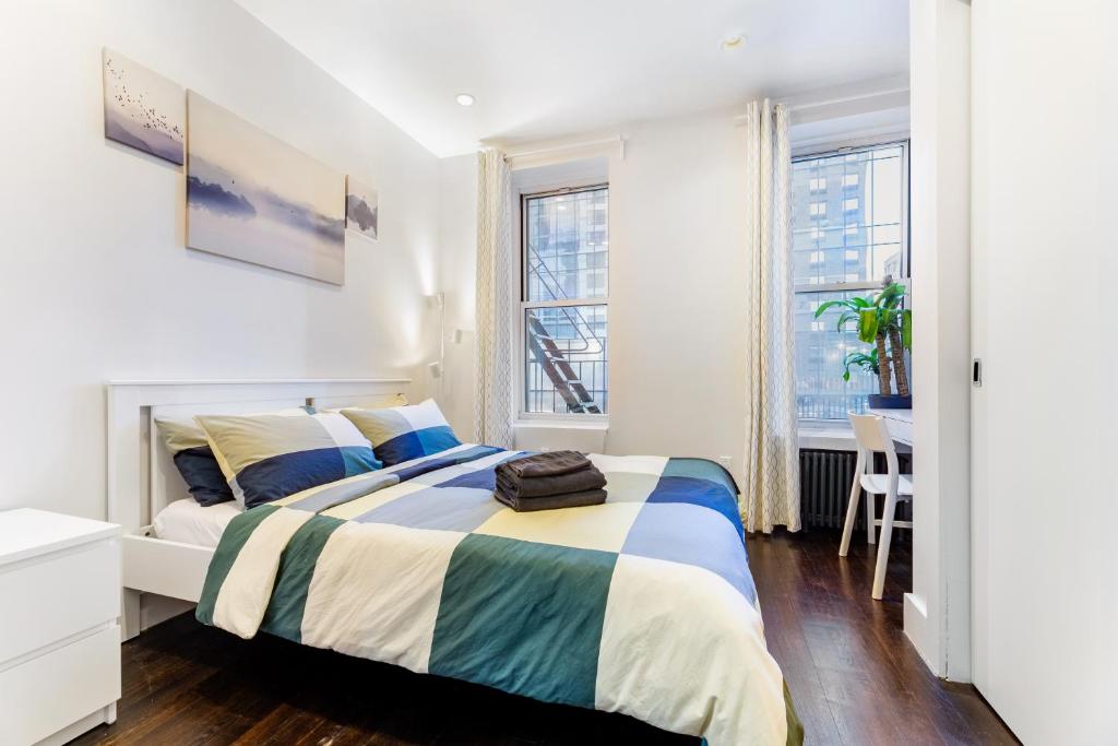a white bedroom with a bed and a desk at 2 Bedroom Luxury Unit in the Heart of Manhattan in New York