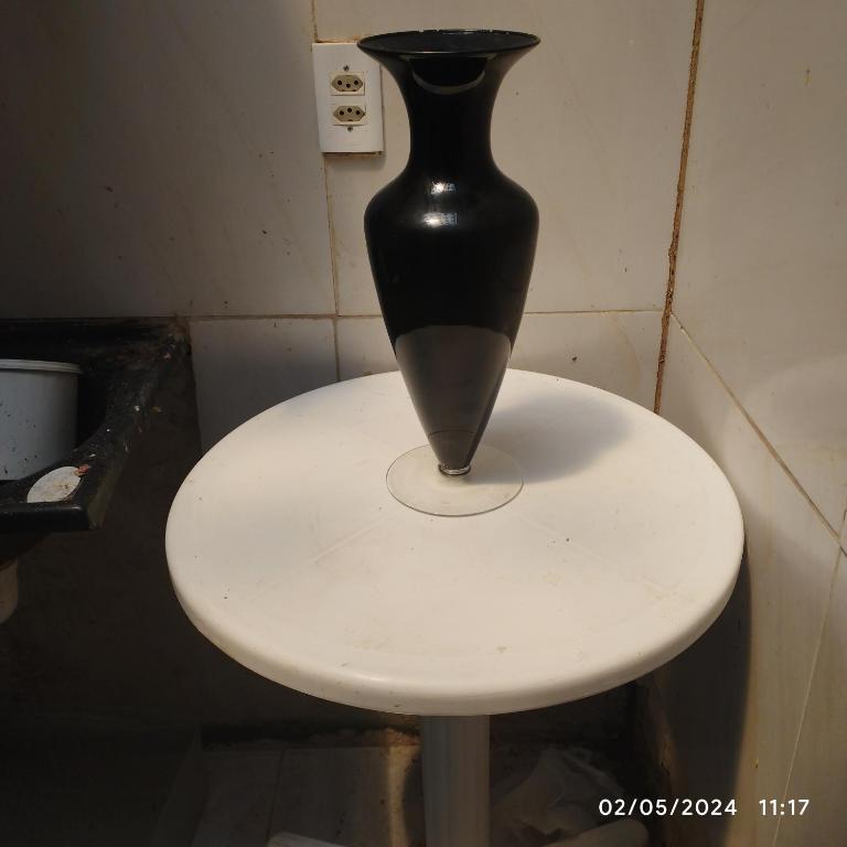 a black vase sitting on top of a white table at Hostel parque ecológico in Juazeiro do Norte