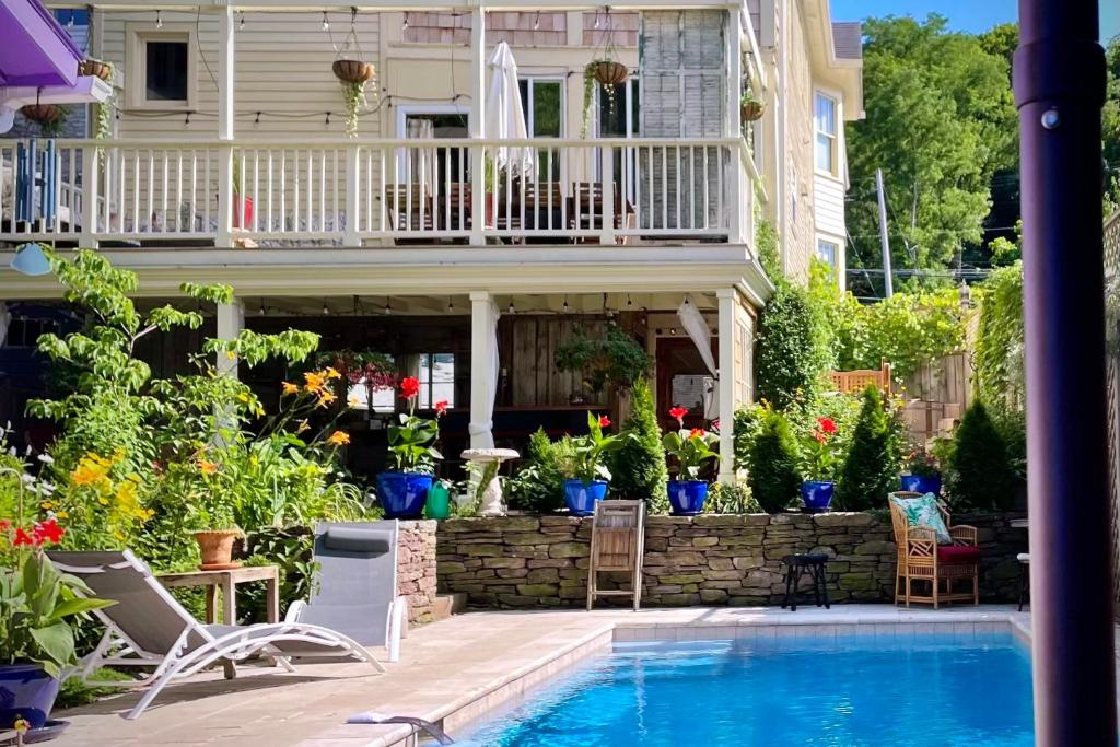 a swimming pool in front of a house with a balcony at Palazzo Hudson - Luxury Pool, Hot Tub, and Sauna in Hudson