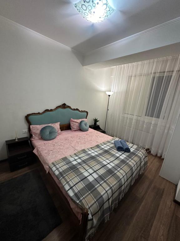 Un dormitorio con una cama con almohadas. en Renthouse Apartments - Feel Like Home, en Chişinău