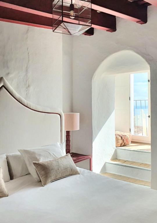 Un dormitorio con una cama blanca y una escalera. en Canalejas 3 Vejer, en Vejer de la Frontera