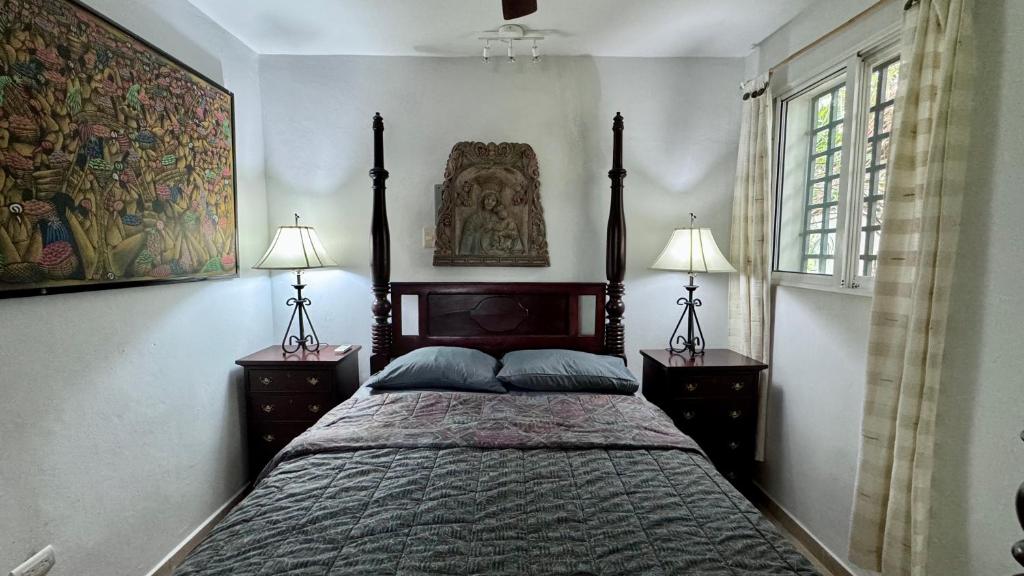 Juan PedroにあるArtgarden Juan dolioのベッドルーム1室(大型ベッド1台、ランプ2つ、絵画付)