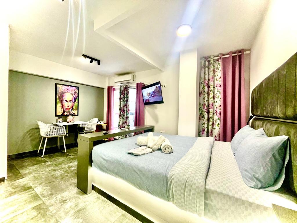 - une chambre avec un lit, un bureau et une table dans l'établissement Mini Suite Home, à Alexandroúpolis