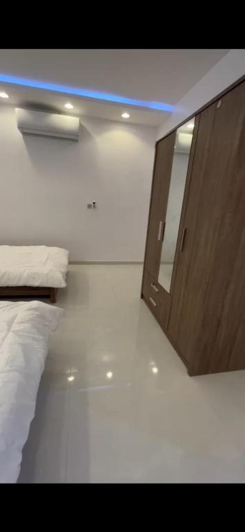 1 dormitorio con espejo junto a la cama en الفهد en Mogayra