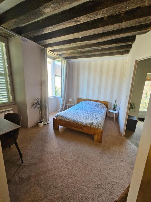 Un pat sau paturi într-o cameră la Chambre avec salle de bain