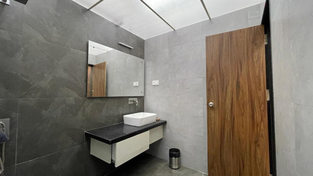 a bathroom with a sink and a mirror at VARDHAN CORPORATE STAY in Pune